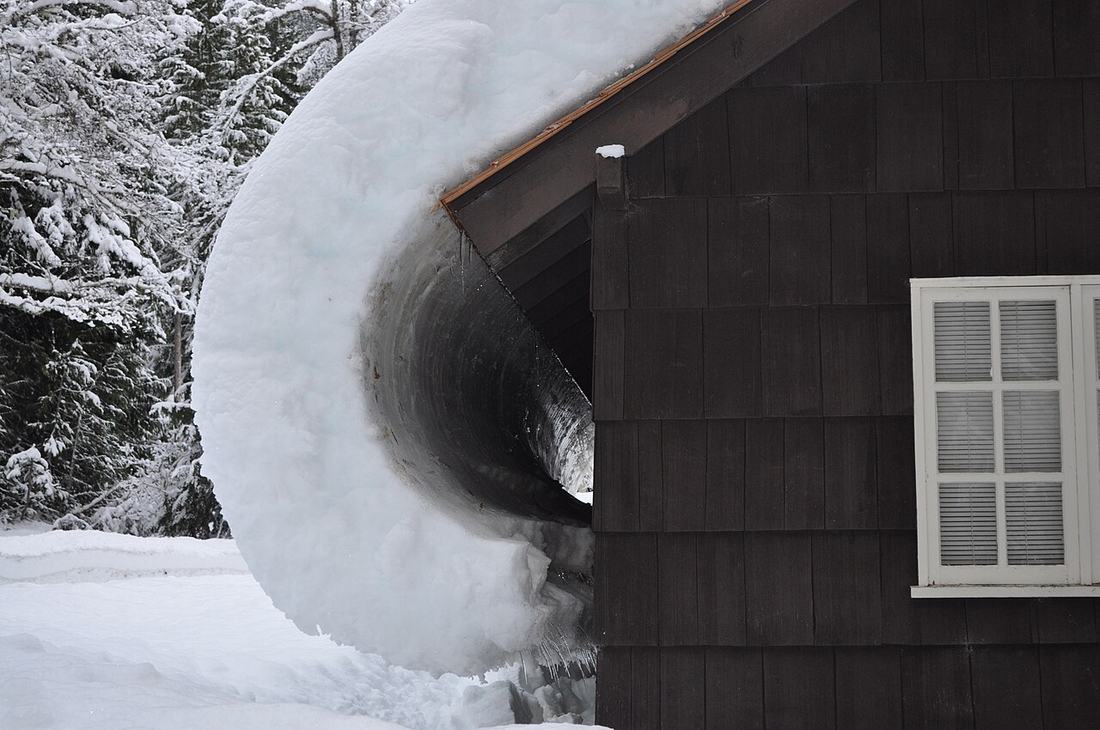 Snow sliding off the roof of a house